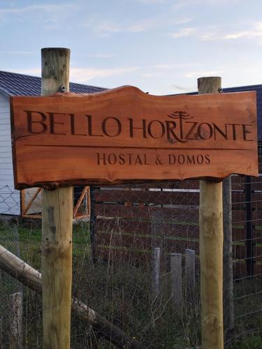 a wooden sign that says beloitoit hospital and dominos at Hostal & Domos Bello Horizonte in Villarrica
