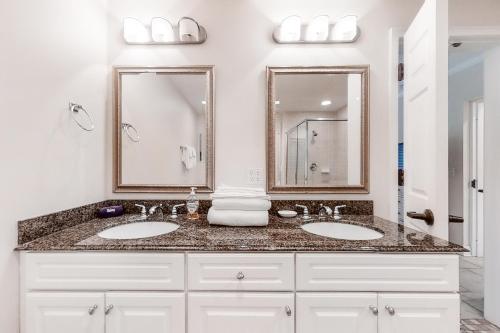 ein Badezimmer mit zwei Waschbecken und zwei Spiegeln in der Unterkunft Wonderful Home Close to Beach w/Shared Pool, Free WiFi, Central AC, W/D in Fernandina Beach