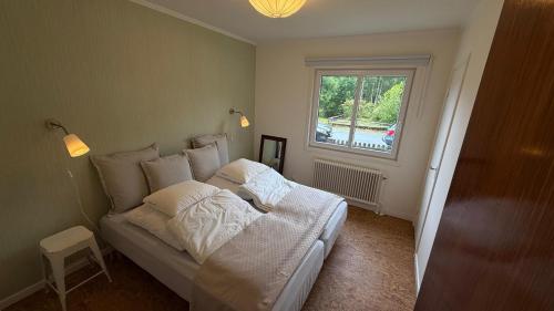 a bedroom with a bed with white sheets and a window at Alsterfors 23 