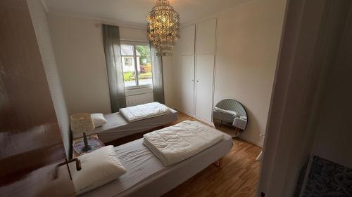 a room with two beds and a chandelier at Alsterfors 23 