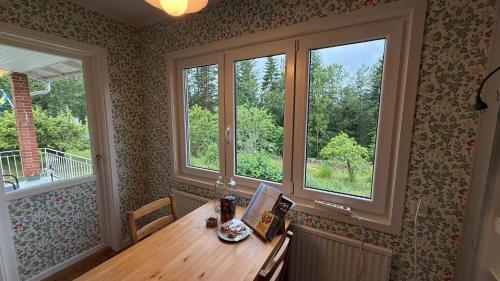 a room with a wooden table and two windows at Alsterfors 23 