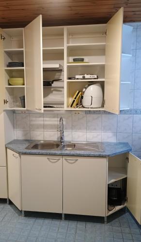 a kitchen with white cabinets and a sink at PitStop 6 in Tampere
