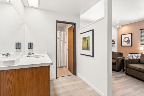 a bathroom with a sink and a living room at Red Roof Inn Ridgecrest in Ridgecrest