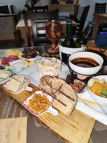 a table with a bunch of food and a bottle of wine at Hostal & Domos Bello Horizonte in Villarrica