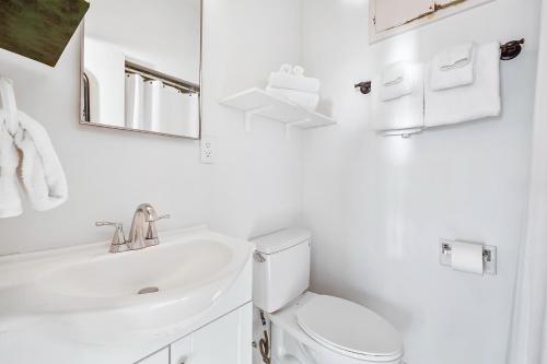 ein weißes Badezimmer mit Waschbecken und Toilette in der Unterkunft 3009 Ocean St E Beautiful Beachfront Condo w/ Ocean Views, Private Patio, Grill, & Free WiFi in Carlsbad