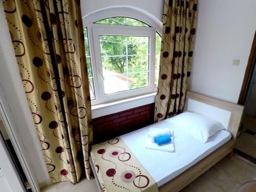 a small bed in a room with a window at Villa Golf 2 in Budva