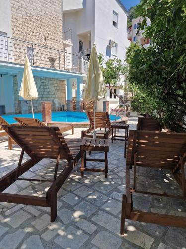 a group of chairs and umbrellas next to a pool at Villa Golf 2 in Budva