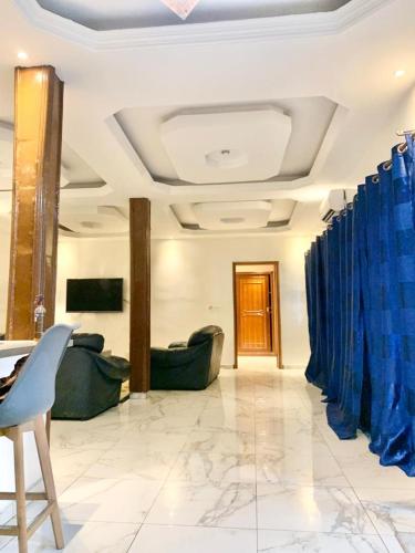 a living room with blue curtains and couches at Appartement meublé avec cuisine équipée, au bord la mer in Guediawaye