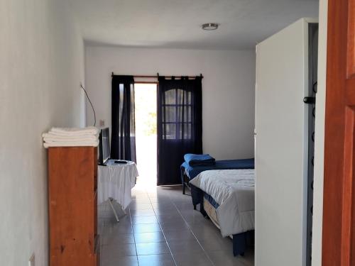 a bedroom with a bed and a door to a window at Departamento Blach in Cafayate
