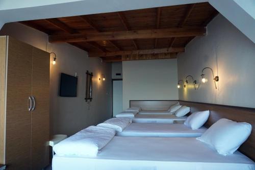 a room with four beds with white pillows at Aqua Boss Hotel in Eceabat