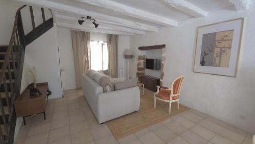 a living room with a white couch and a chair at L'Hirondelle in Airvault