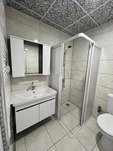 a bathroom with a shower and a sink and a toilet at Blue Lake Otel in Beysehir