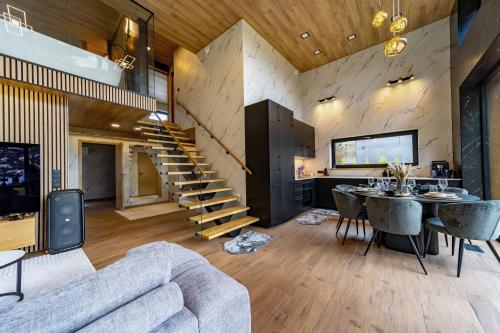 a living room with a couch and a table and a staircase at Green Field Villa in Kuressaare