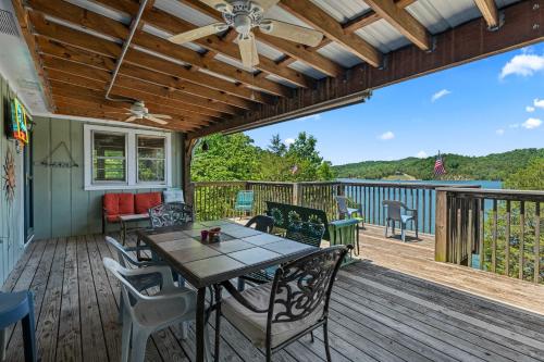 a patio with a table and chairs on a deck at Rustic Lakefront Home with Beach in Sevierville