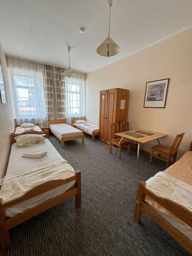 a room with three beds and a table and chairs at Litinterp in Vilnius