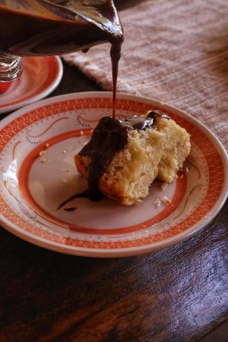 ein Stück Essen auf einem Teller mit Schokoladensoße in der Unterkunft Vila Ohana Beira Mar - Xandó-Caraíva in Caraíva