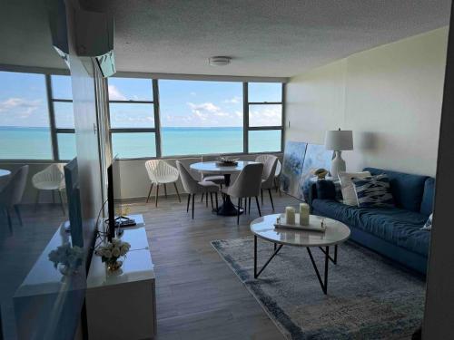 a living room with a blue couch and a table at Beachfront Balcony With Marina Views Pool in Fajardo