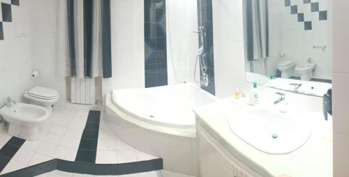 a white bathroom with a sink and a toilet at Appartamento vista mare in Castellammare del Golfo