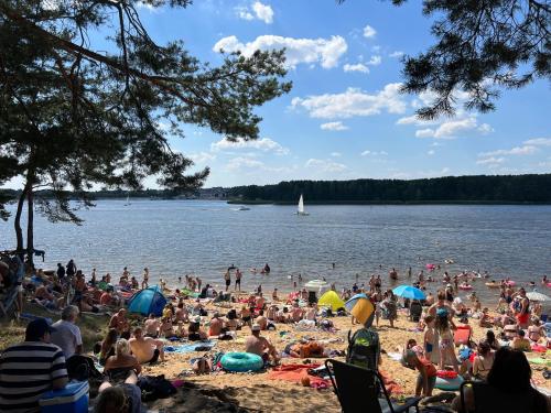 a crowd of people on the beach at a lake at Family & Business Sauna Apartments No2 Leśny nad Zalewem Cedzyna - 2 Bedroom with Private Sauna, Bath with Hydromassage, Terrace, Parking, Catering Options in Kielce