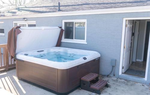 a large hot tub sitting outside of a house at Mason Marvel Luxe Stay with Pool and Hot Tub in Mason
