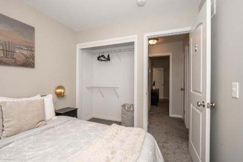 a white bedroom with a bed and a hallway at The Gem Vacation Rental in Walton