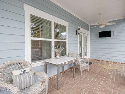 a porch with a table and chairs and a television at 3 Bed, 2 and a half bath Gorgeous Coastal Home 1 block from beach! in Long Beach