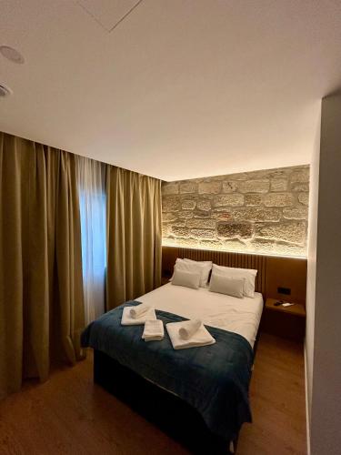 a bedroom with a bed with two towels on it at Aquae Flaviae Urban Stay - Style in Chaves