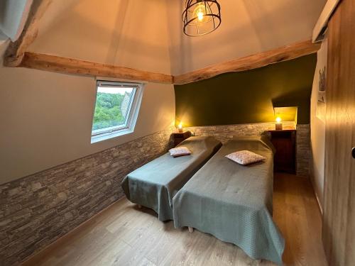 a bedroom with a bed and a window at Le relais du Château in Fatouville-Grestain