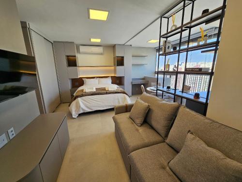 a living room with a couch and a bed at Studio Tatuapé - SP in São Paulo