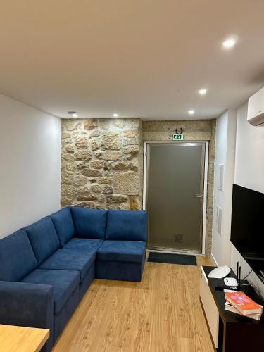 a living room with a blue couch in front of a door at Aquae Flaviae Urban Stay - Style in Chaves