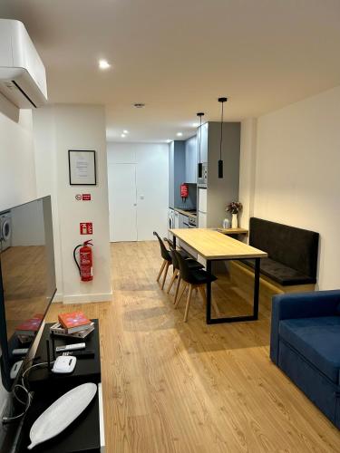 a living room with a table and a blue couch at Aquae Flaviae Urban Stay - Style in Chaves