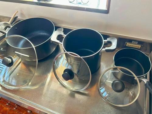 three pots and pans sitting on a stove top at 鳴門市の貸切一軒家最大10名無料駐車場5台 in Naruto