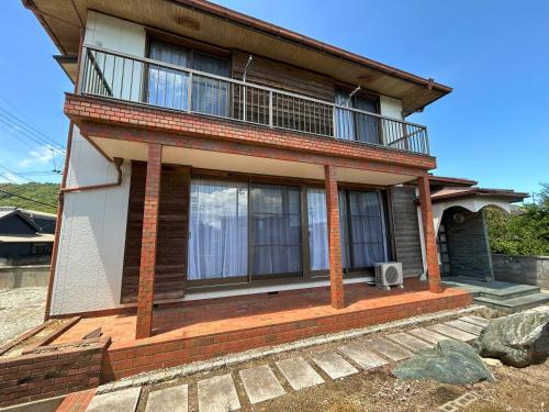 a house with a balcony on top of it at 鳴門市の貸切一軒家最大10名無料駐車場5台 in Naruto