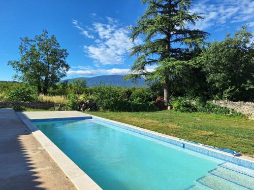 - une piscine dans une cour avec un arbre dans l'établissement Le Portail Vert, à Villes-sur-Auzon