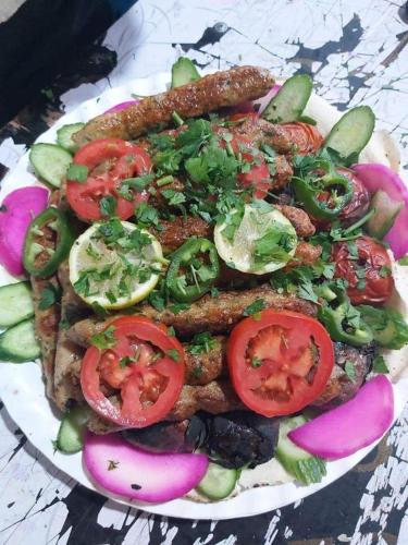 a plate of food with vegetables on a table at Nargges House in Al Salt