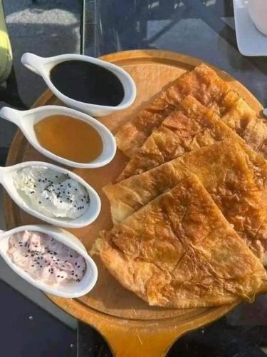 a plate of food with bread and dipping sauce at Nargges House in Al Salt