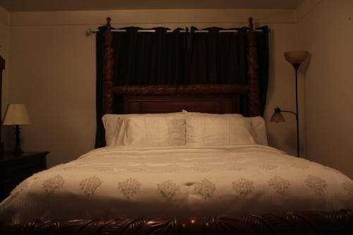 Oak ParkにあるBeautiful, Cozy Stay in Oak Park, Queen Bedroom, Work Setup & Backyard Grillの木製のヘッドボードが付いた大きなベッドのある寝室