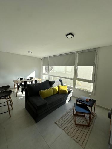 a living room with a black couch and a table at Raíz Urbana in Tandil