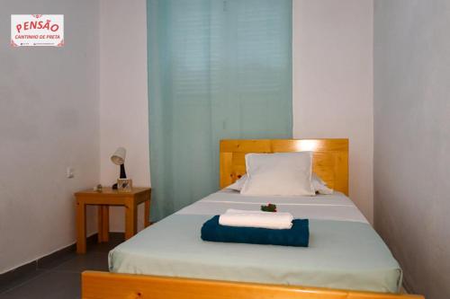 a bedroom with a bed with two towels on it at Pousada Cantinho de Preta in Seladinha