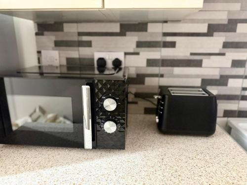 a room with a glass table with a speaker and a glass table with a computer at The Edgbaston Retreat in Birmingham