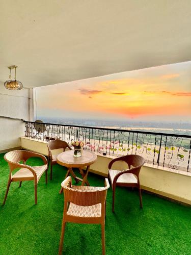 a table and chairs on a balcony with a view of the ocean at Spacious 3BR Maadi Stay Close to Nile Corniche in Cairo
