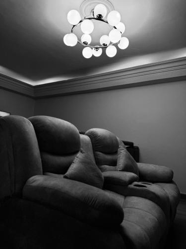 a couch sitting in a living room with a chandelier at Spacious 3BR Maadi Stay Close to Nile Corniche in Cairo