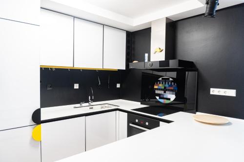 una cocina blanca con paredes negras y armarios blancos en Kolareva - ZAG airport - self check in&out - shuttle service - free parking, en Velika Gorica