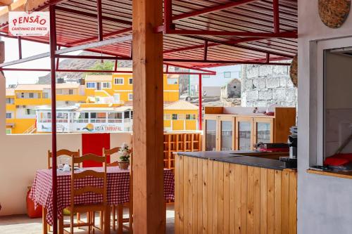 a kitchen with a table and chairs on a balcony at Pousada Cantinho de Preta in Seladinha