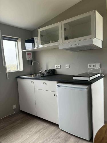 a kitchen with white cabinets and a sink at Uxahryggur in Hvolsvöllur