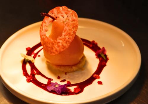a plate of food with a donut and sauce at JetPark Auckland Airport Hotel in Auckland