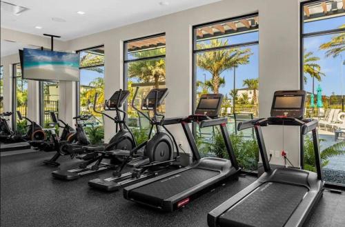 a fitness room with treadmills and elliptical machines at Experience Luxury In Your 11 En-suites Mansion in Orlando