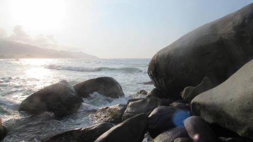 a group of rocks in the water next to the ocean at HOSTAL MIRADOR dentro del parque tayrona in El Zaino