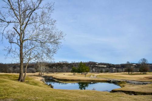 a tree sitting next to a pond on a golf course at Birdie's Bliss 2BR Condo Sleeps 6 in Lake Ozark
