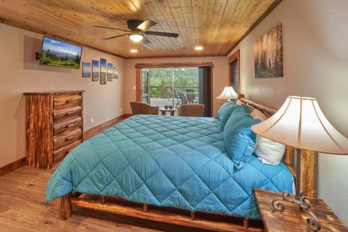 a bedroom with a bed with a blue comforter at How Sweet It Is in Pittman Center